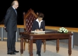 Man looking at Governor General signing on table seat in chair