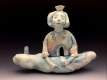 ceramic sculpture of a person sitting on a cloud