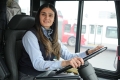 Aditi, chauffeuse d’autobus, est assise derrière le volant de son autobus d’OC Transpo.