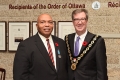 Le récipiendaire du prix, M. Walters, et le maire Jim Watson posent pour une photo devant l'exposition de l'Ordre d'Ottawa.