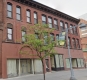Historic brick storefront with boarded up windows at ground level located at 152 Bank Street.