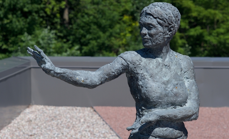 Image d’une sculpture de femme en bronze effectuant le mouvement de taï-chi « mouvoir les mains comme les nuages ».