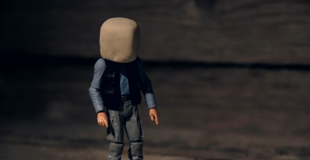 Poseable plastic male figure with a block of clay covering his head.