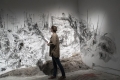 person standing in front of a charcoal drawing on drywall
