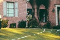Firefighter outside charred brick building / Pompier à l'extérieur d'un bâtiment en briques carbonisé
