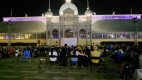 A crowd gathered watching a movie at Lansdowne Park in the evening.