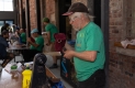 An Ottawa Tool Library volunteer in a green t-shirt and black baseball cap examines a kitchen knife. 