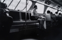 Black and white photograph of a person sitting on the bus