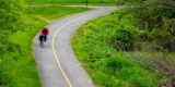 A lone cyclist rides on a bike path