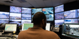 A back view of Bashir Mohamed, an Analyst with Traffic Monitoring and Signal Control Systems, as he monitors the many screens and data input sources at the City’s Traffic Control Centre.