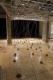 Empty gallery with string grid on ceiling that lead to many clay balls on the floor