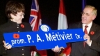 Mayor and guests holding a street sign 