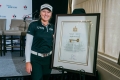 Brooke Henderson standing beside framed Key to the City plaque