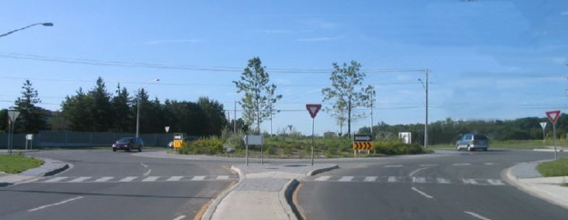 This is a two-lane roundabout. A modern roundabout is a circular intersection without traffic signals that is designed to maximize safety and minimize traffic delay.