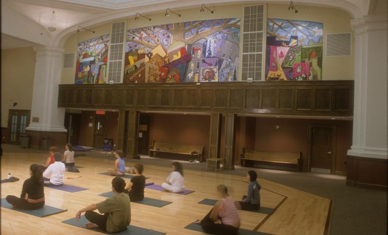 Image de la murale décrite dans une salle où des personnes font du yoga.