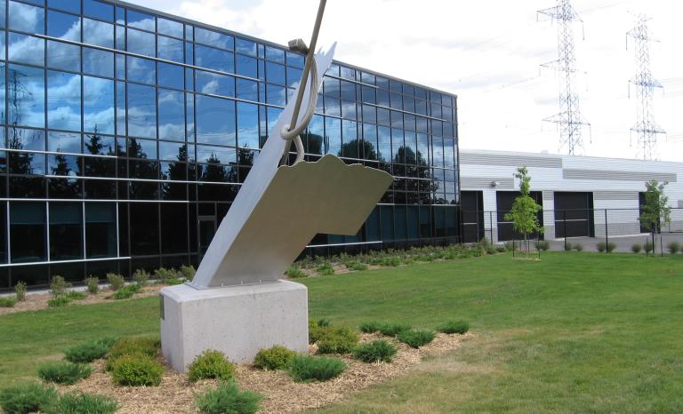 Image d’une sculpture de béton et d’acier installée devant le bâtiment.