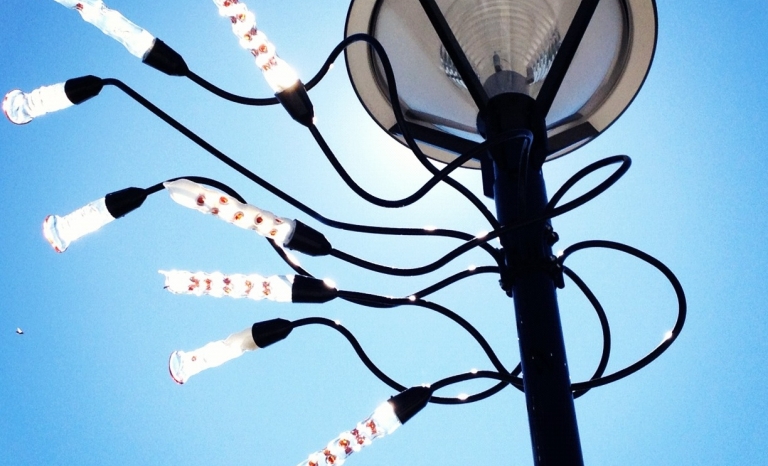 Lampadaire orné de vrilles et de formes en verre ressemblant à des gousses.