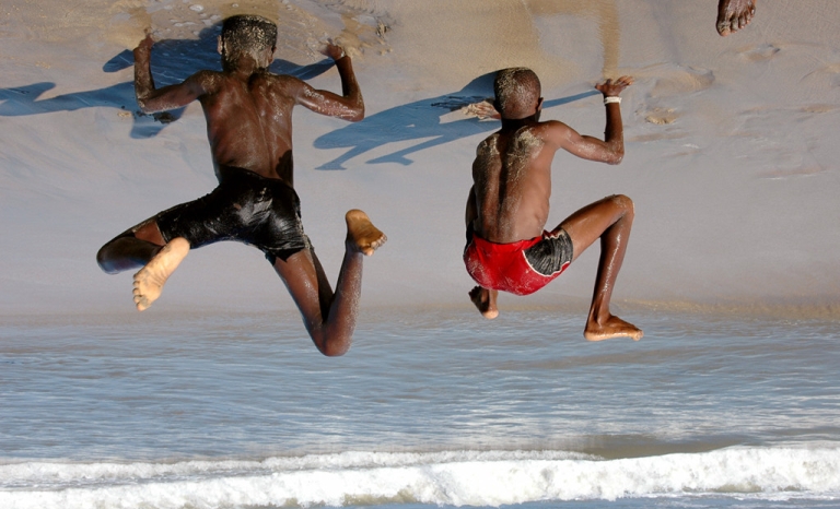 L'image montre deux jeunes garçons essayant de faire le poirier sur la plage d'Accra, au Ghana.