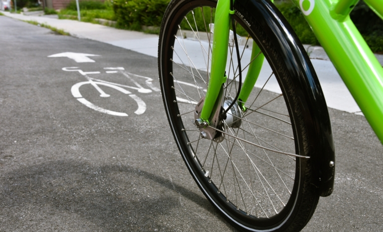 Close-up of a front wheel of a bike travelling in a bike lane