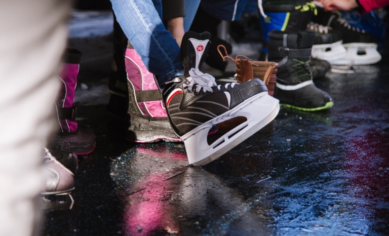 A group of people putting on skates at an outdoor rink