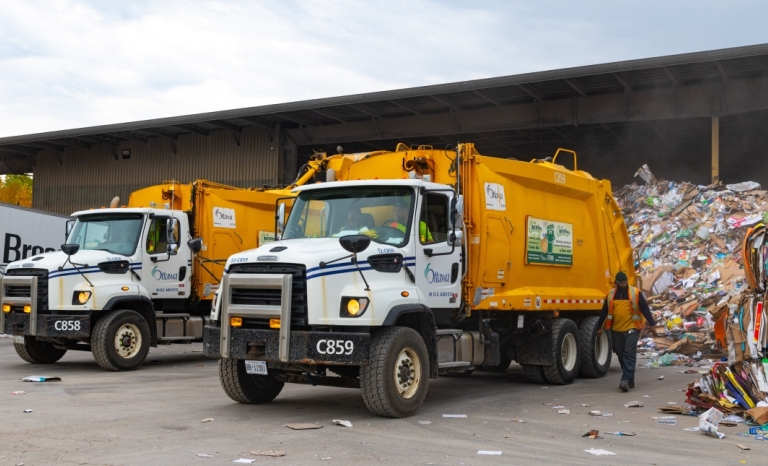 Two trucks emptying recyclable material at Cascades Material Recycling Facility