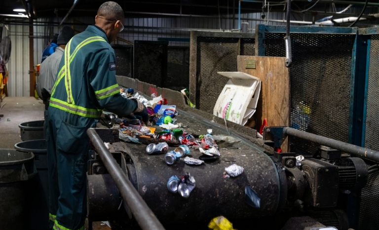 Worker sorting recycled material at Cascades Recycling Facility