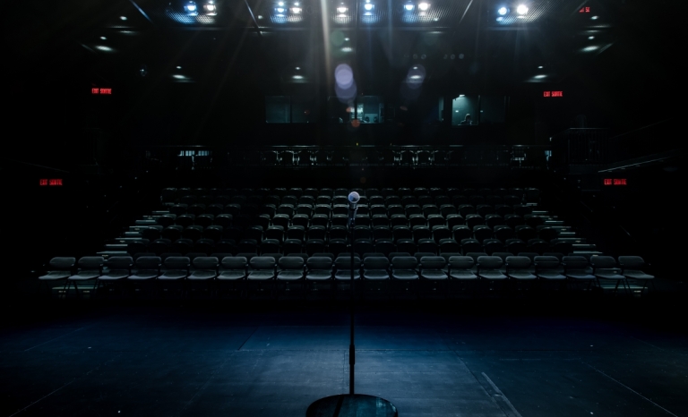 Lumières de théâtre éclairant un pied de micro sur une scène