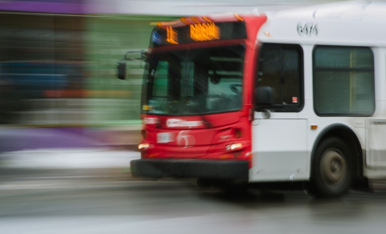 An OC Transpo bus driving by with motion blur