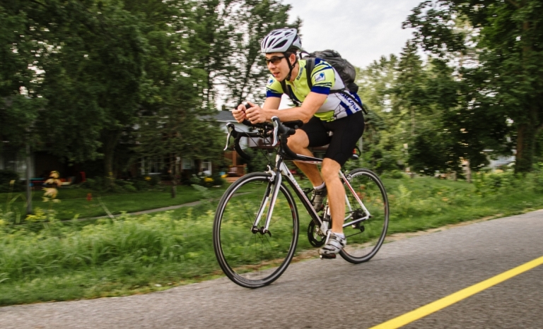 A cyclist with racing gear travelling on a bike path