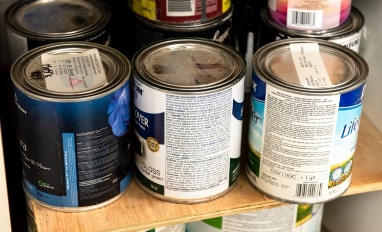 A shelf with paints and wood stains in a workshop