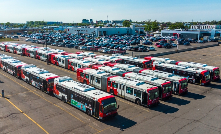 Drone shot of OC Transpo headquarters parking lot with many busses parked in rows