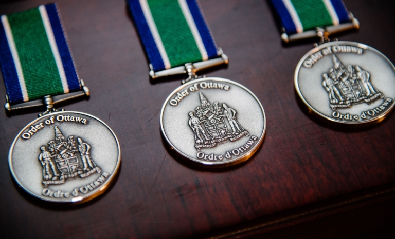 A row of round medallions with the Ottawa Coat of Arms embossed on them.