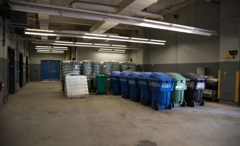 A row of recycling bins and compost bins