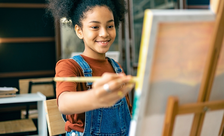 Image showing a young woman painting on a canvas.