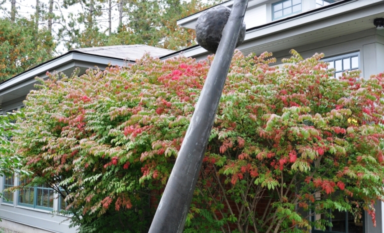 A bronze sculpture of a sundial stands approximately three stories tall outside the community centre.