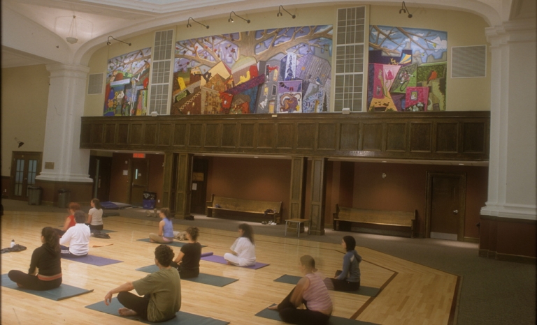 Image of the described mural in a room with people practising yoga