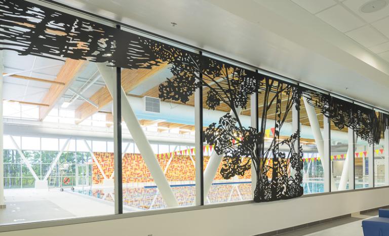Steel cutout mural of landscape with a tree
