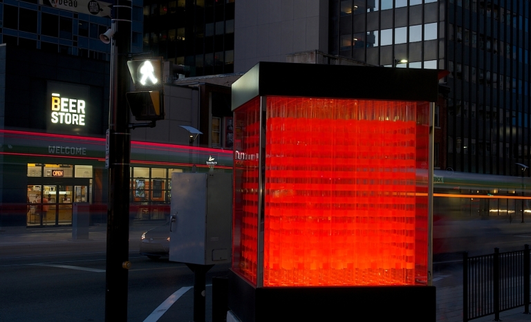 Nighttime image of sculpture titled Cube.