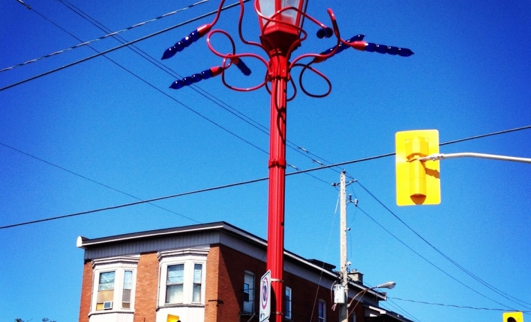 Image of a red lamppost with blue abstracted glass flowers.