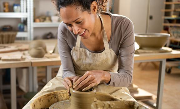 person sitting at pottery wheel