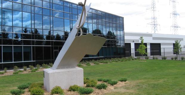 Image d’une sculpture de béton et d’acier installée devant le bâtiment.