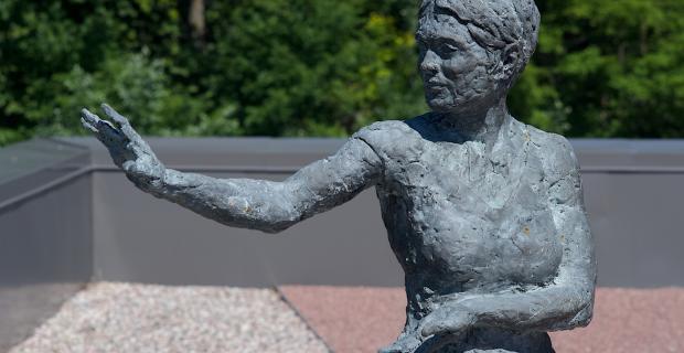 Image d’une sculpture de femme en bronze effectuant le mouvement de taï-chi « mouvoir les mains comme les nuages ».
