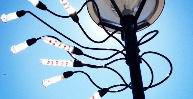 Lampadaire orné de vrilles et de formes en verre ressemblant à des gousses.