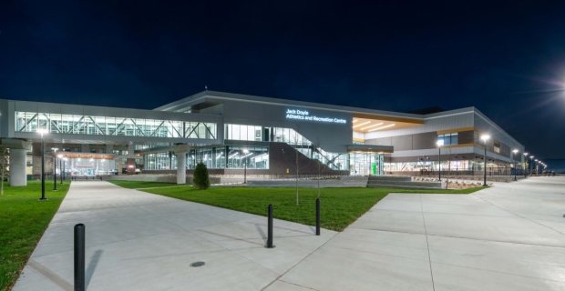 The inviting exterior of the new Jack Doyle Athletics and Recreation Centre is lit up at night.