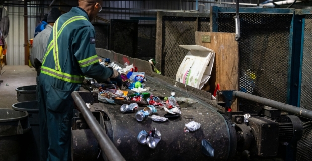 Worker sorting recycled material at Cascades Recycling Facility