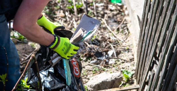 A worker placing litter in a trash bag