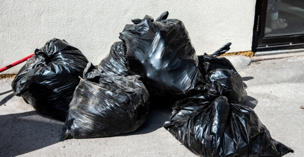 Five full garbage bags on the sidewalk