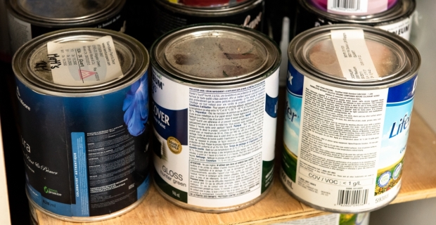 A shelf with paints and wood stains in a workshop