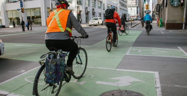 A row of cyclists during morning commute on a segragated bike lane on Laurier Ave