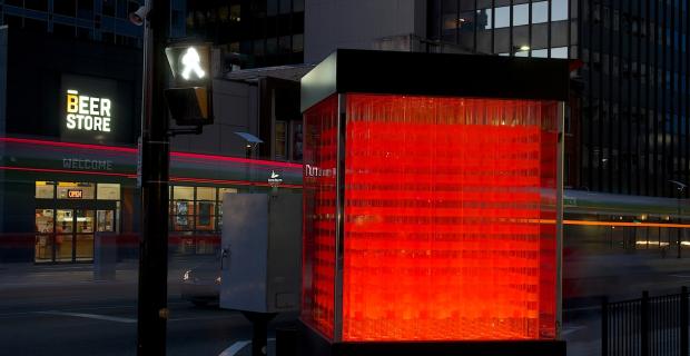 Nighttime image of sculpture titled Cube.